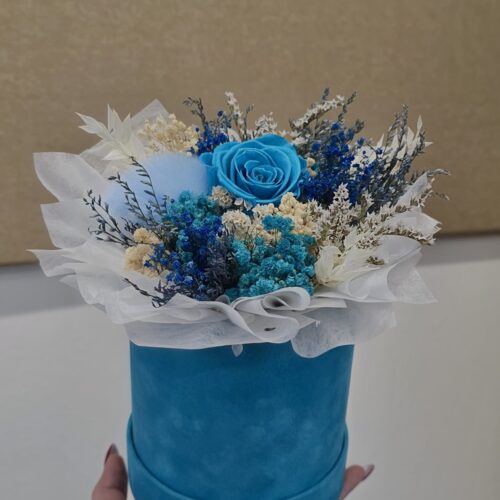 Roza cvjetna kutija sa žutim cvijetom i nježnim detaljima.